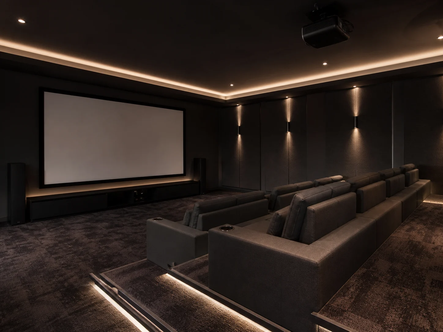 Modern basement home theater with tiered seating and LED lighting