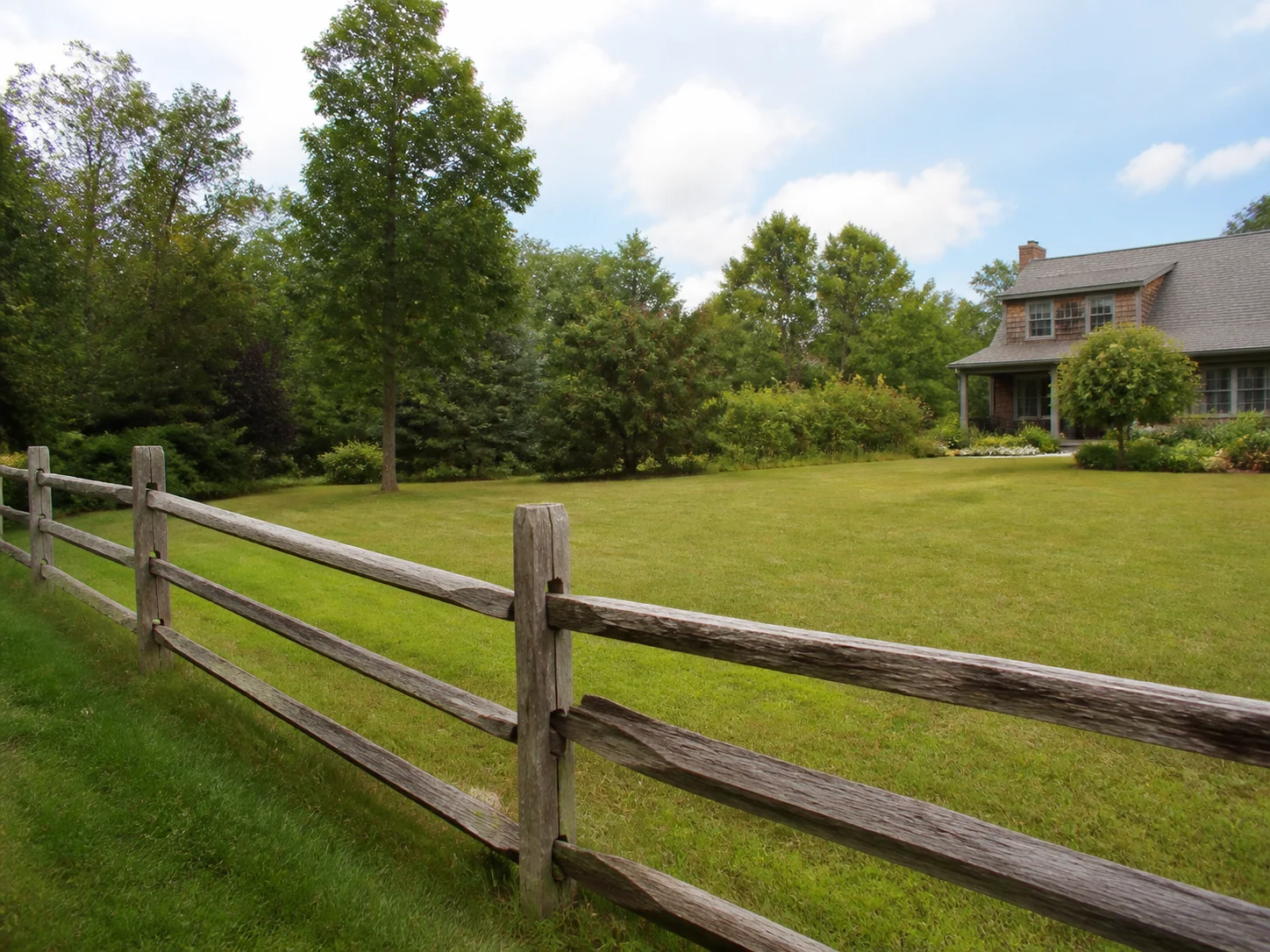 Rustic split-rail fence bordering an open yard