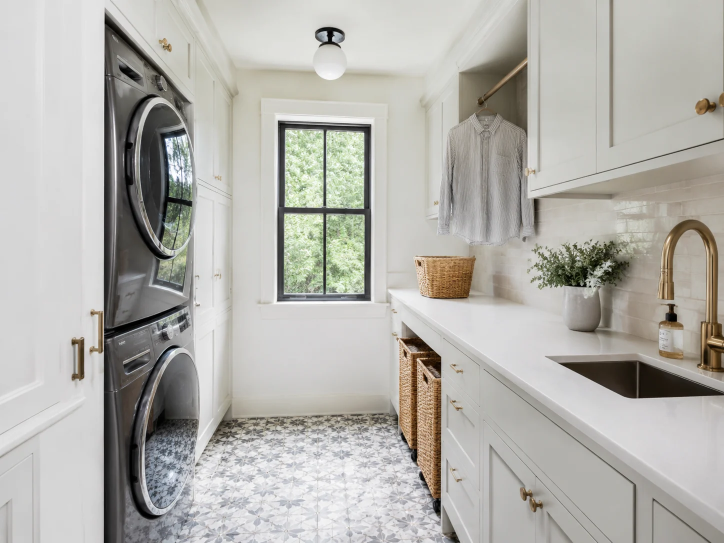 Modern laundry room design with stacked washer and dryer, cabinetry, and folding counter
