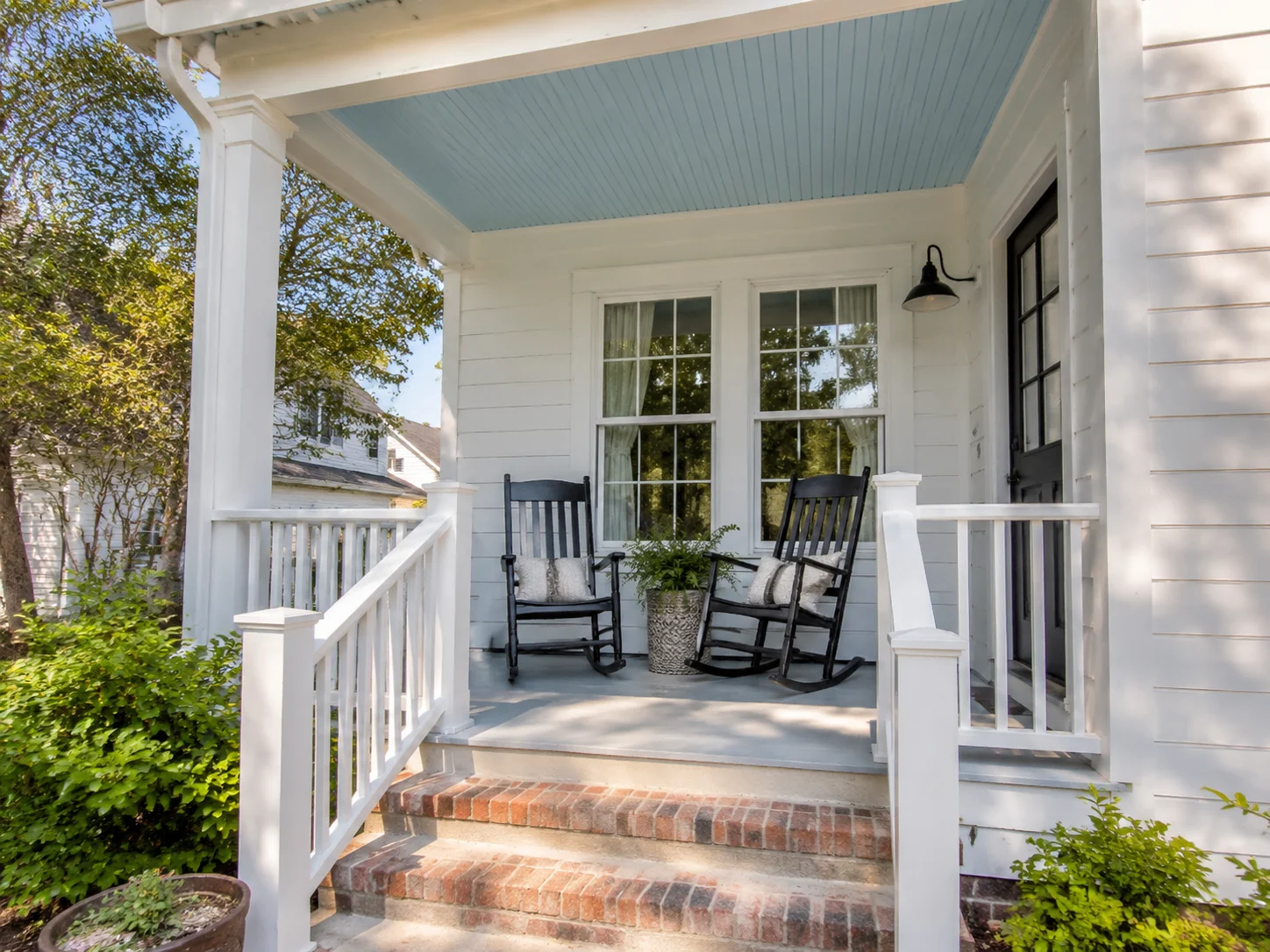 Small front porch refreshed on a budget with new paint, railings, and a blue ceiling