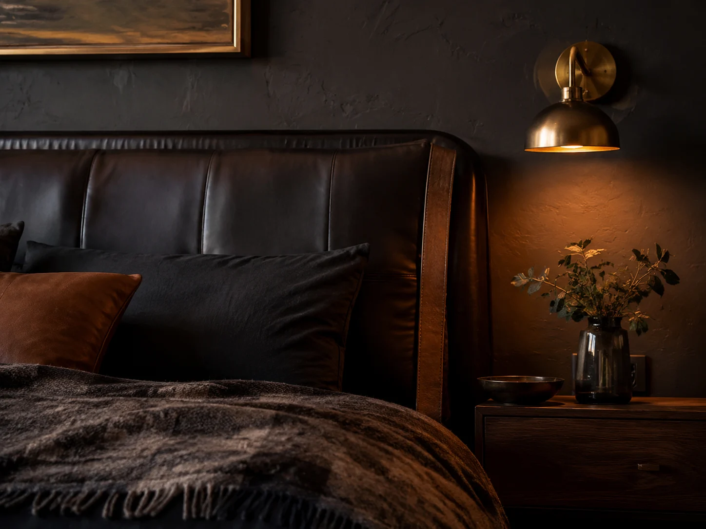 A moody masculine bedroom with dark walls and leather accents